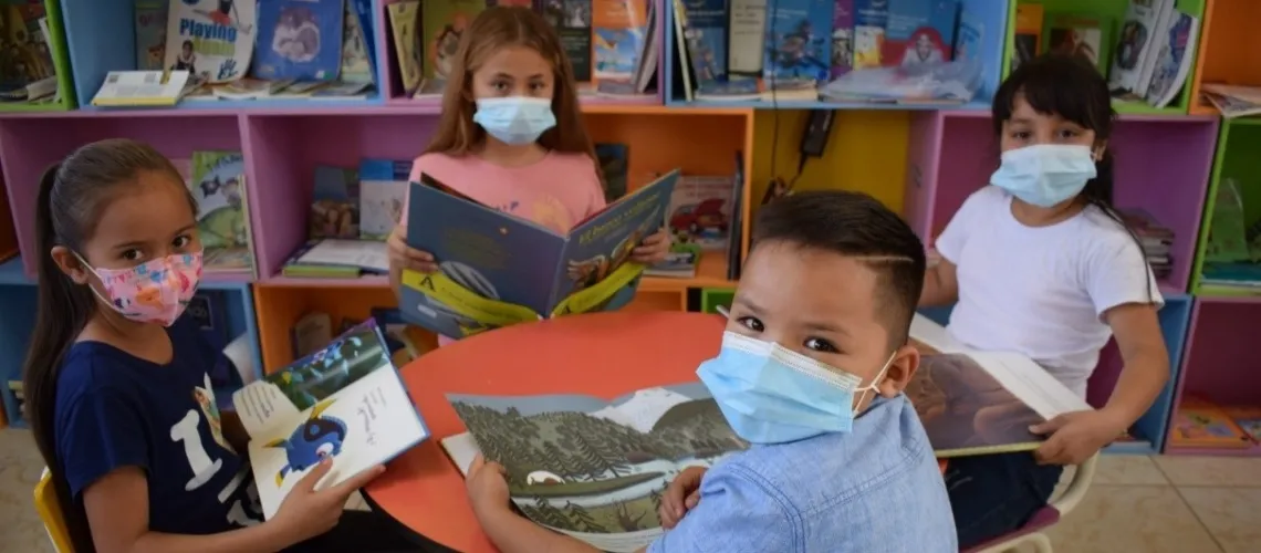 Children reading new library books at a school library in Lempira Department, Honduras.